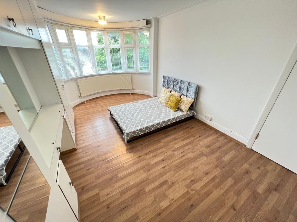 A bright and airy double bedroom featuring a la...