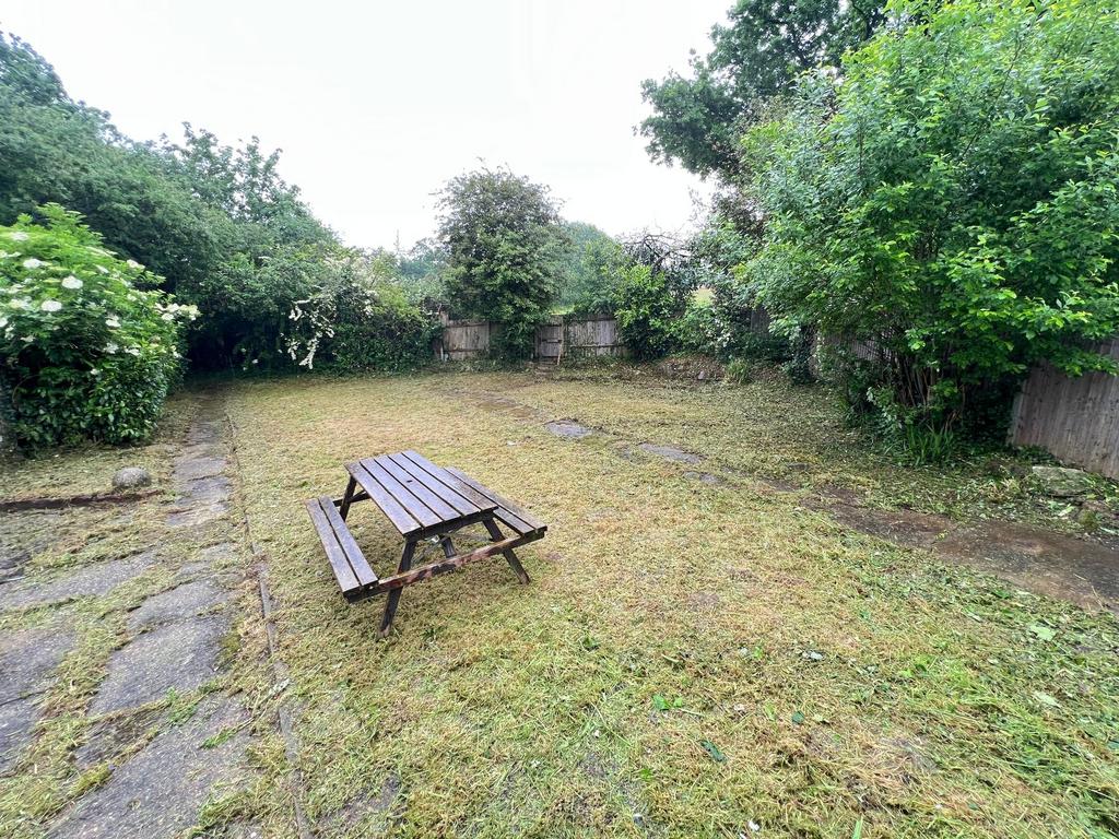 A spacious garden featuring freshly cut grass s...