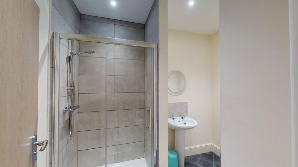 A modern bathroom featuring a walk-in tiled sho...