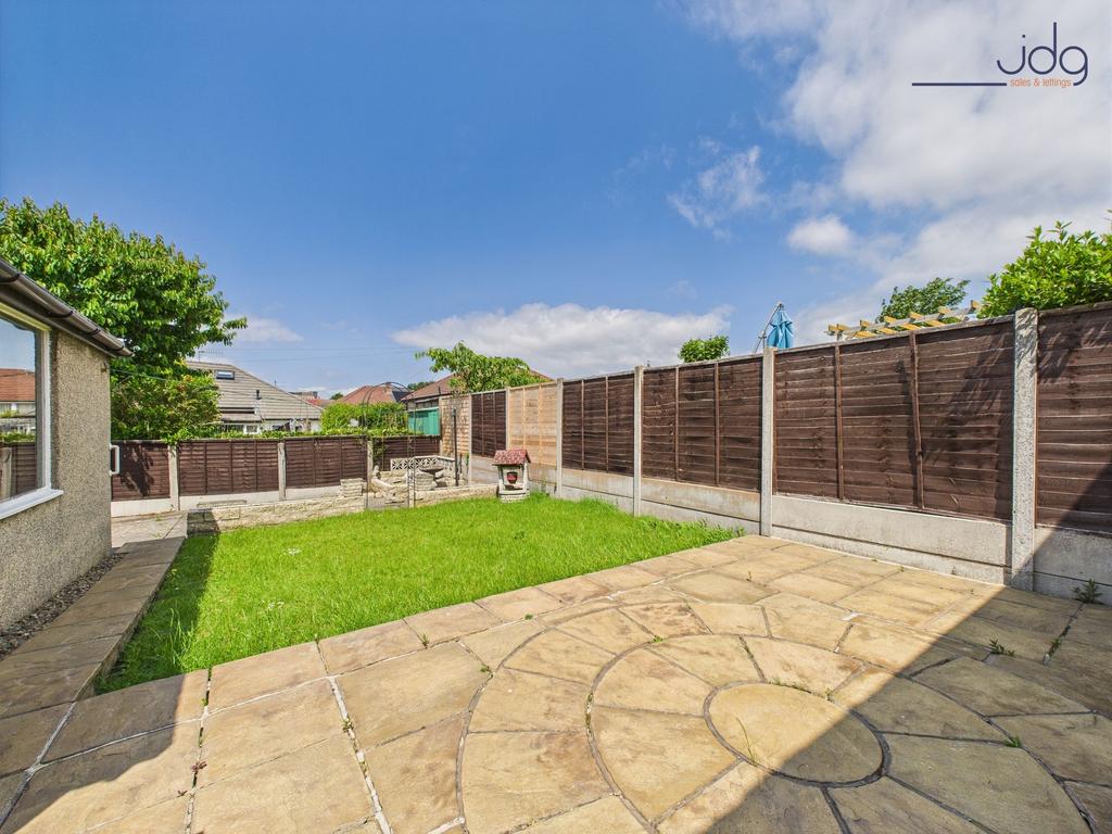 Generously sized garden with a patio and lawn