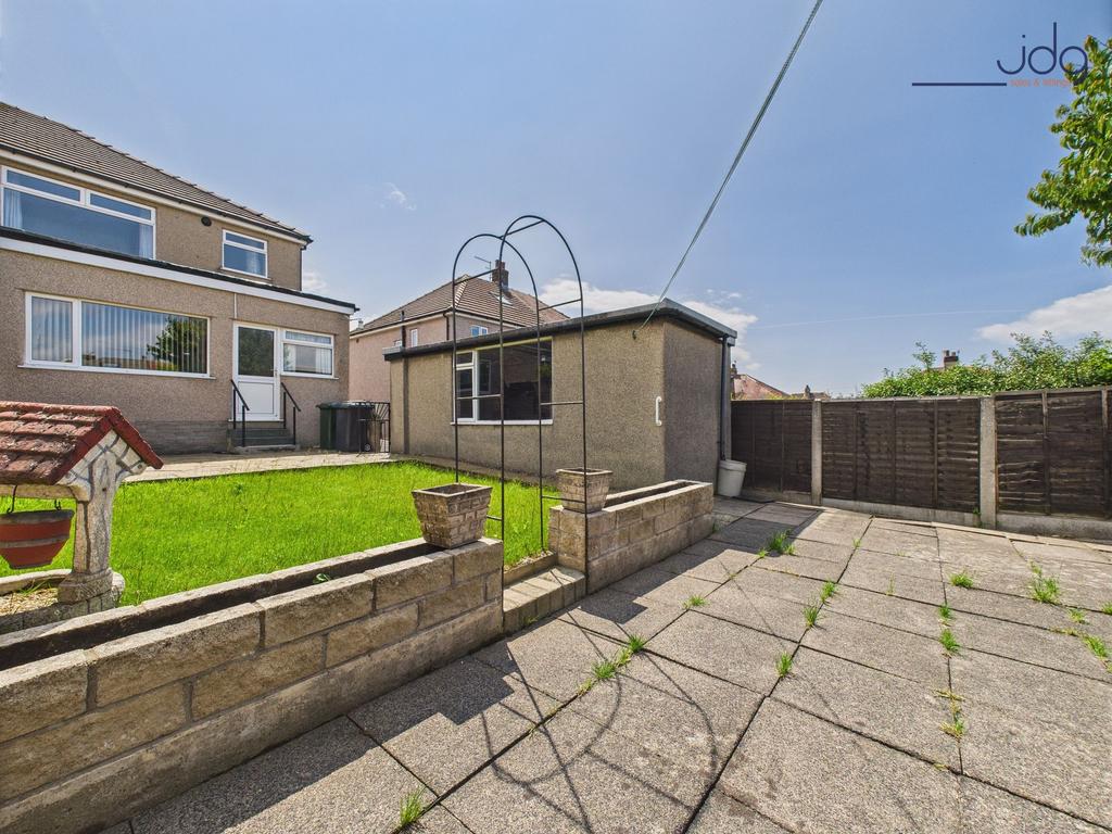 Generously sized garden with a patio and lawn
