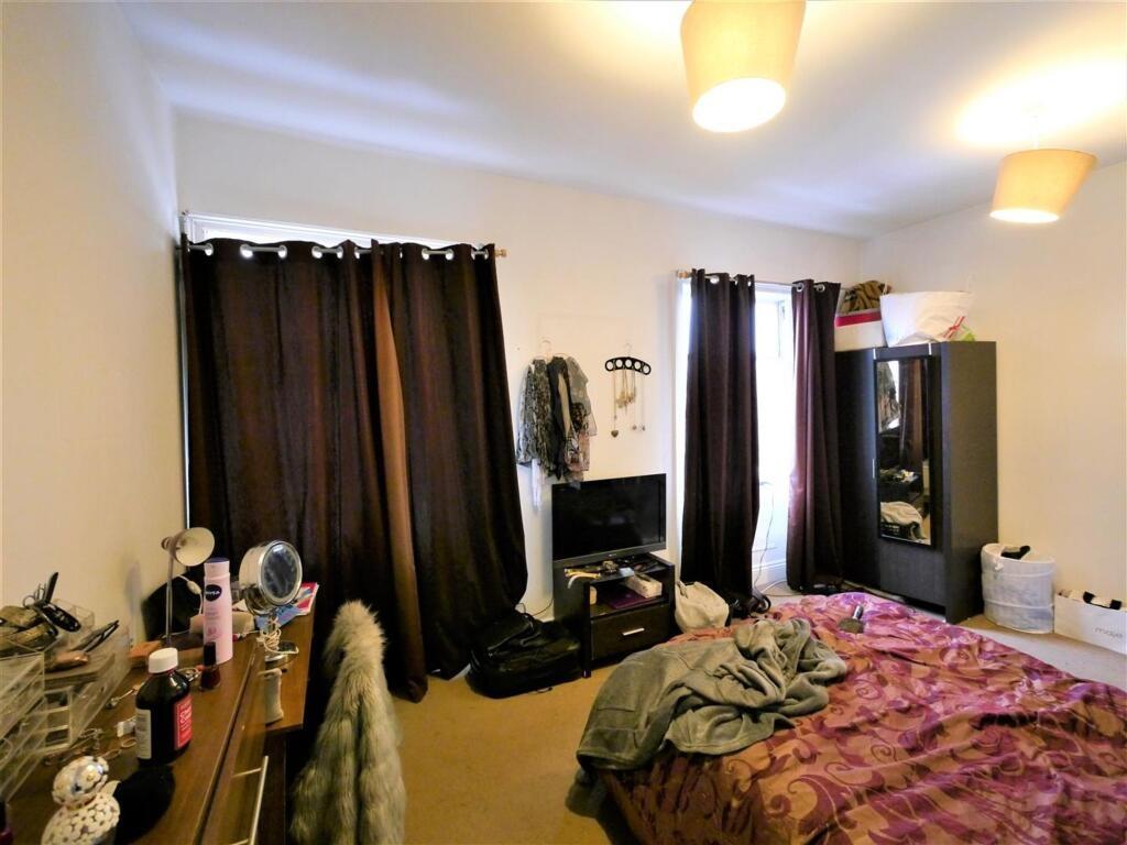 A comfortably furnished bedroom featuring a dou...