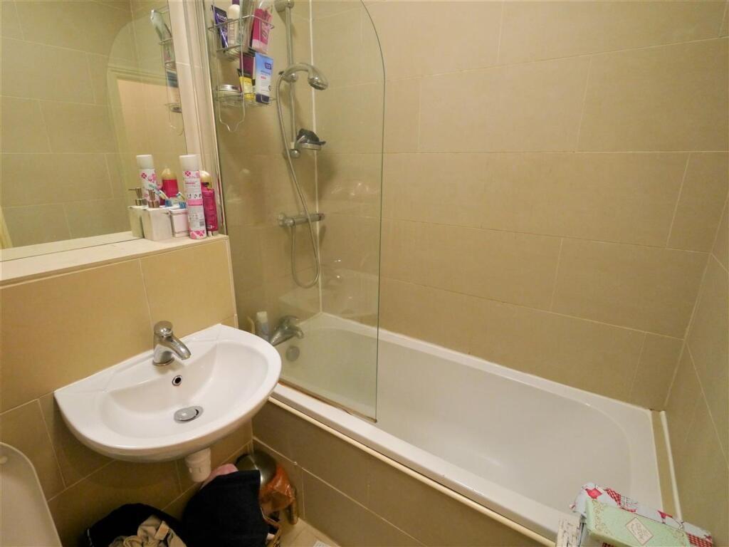 A spacious modern bathroom featuring a large ba...