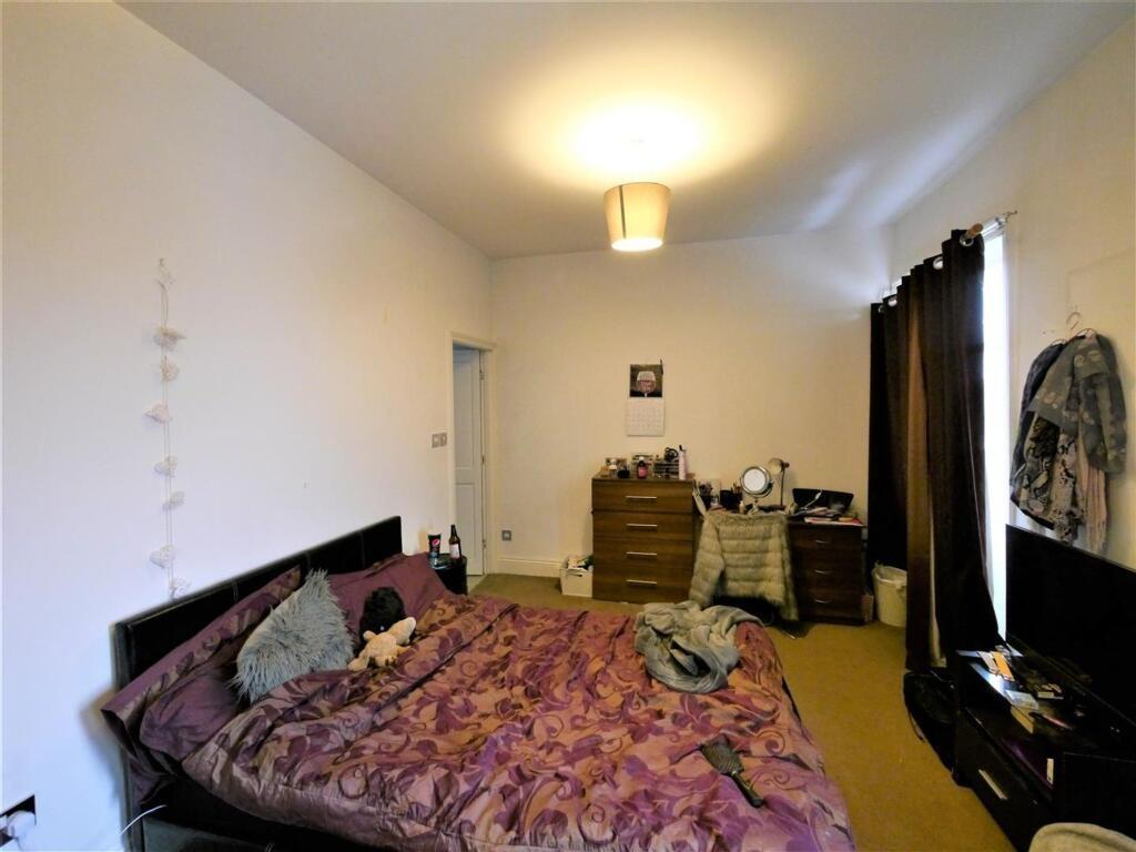 A cozy bedroom featuring a double bed with a fl...
