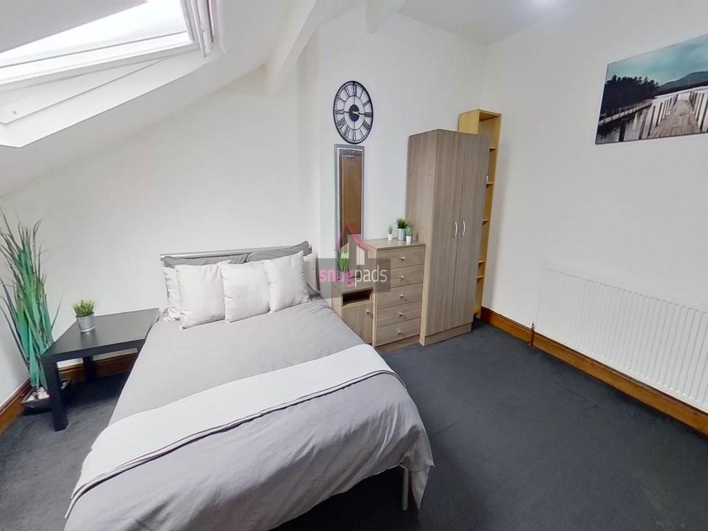 Bright and cozy bedroom featuring a comfortable...