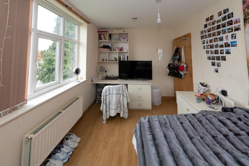 A cozy single bedroom featuring a large window ...