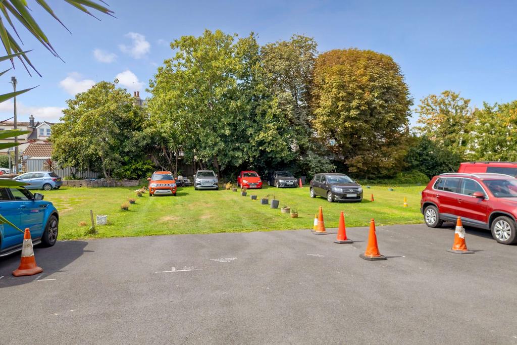 Parking area with garden seating at far end
