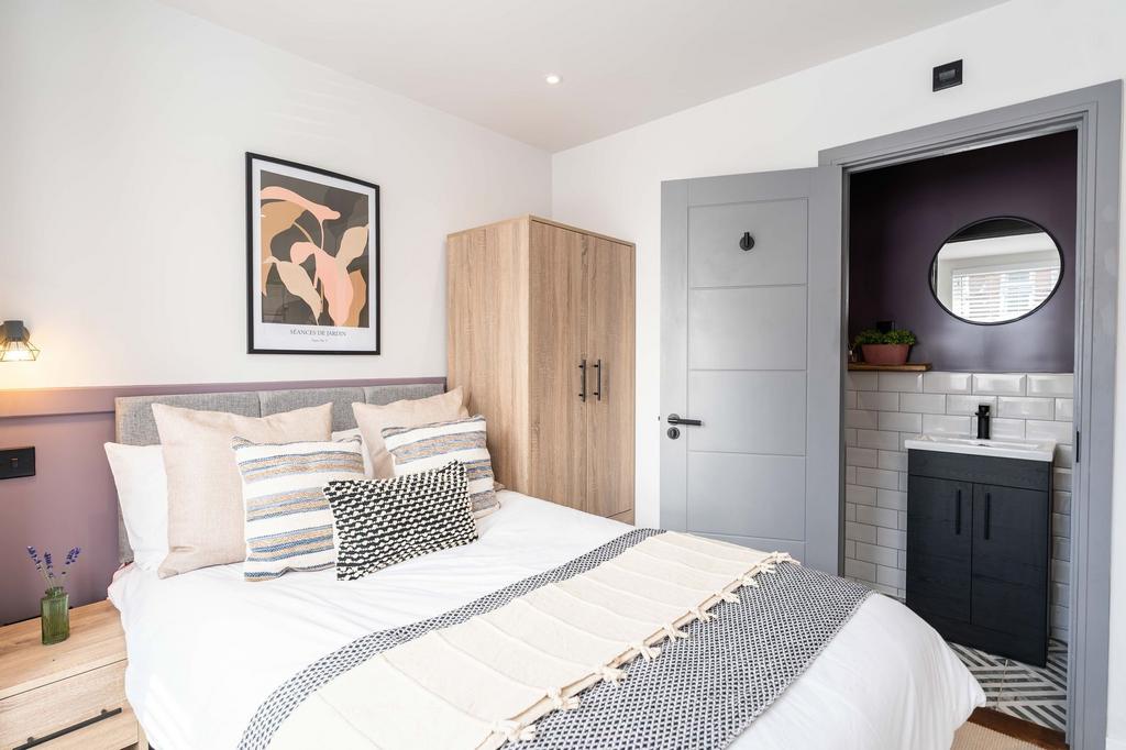 Bright, modern master bedroom featuring a large...