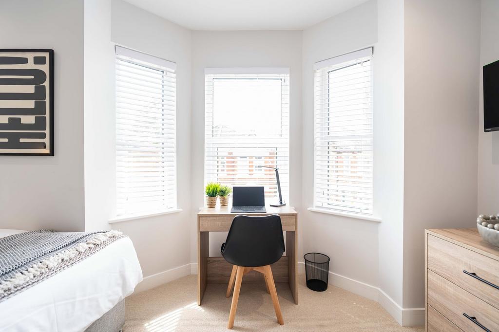 Bright and welcoming bedroom featuring a spacio...