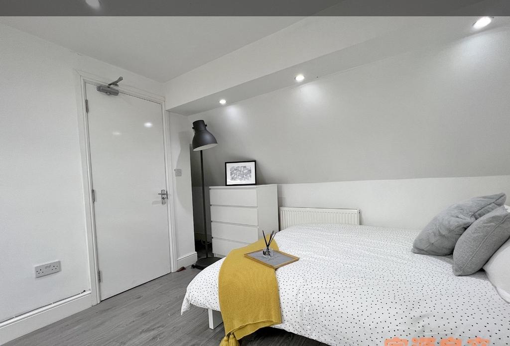 A cozy single bedroom featuring a neatly made b...
