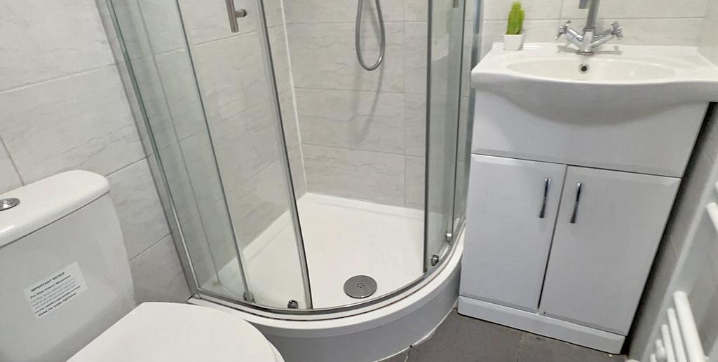 Modern bathroom featuring a curved glass shower...