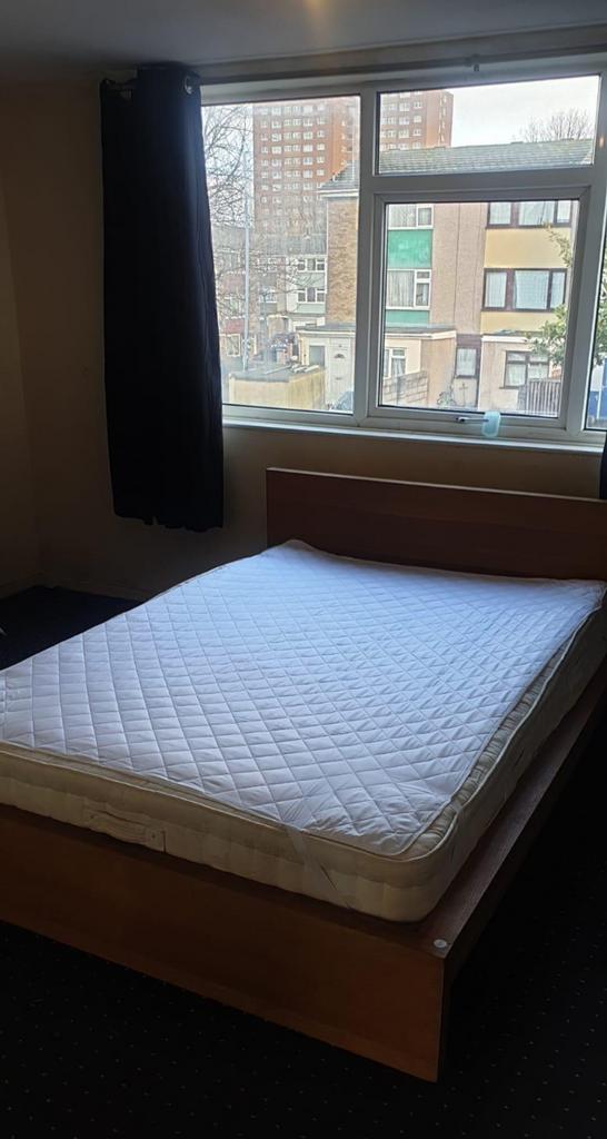 A spacious double bedroom with ample natural li...