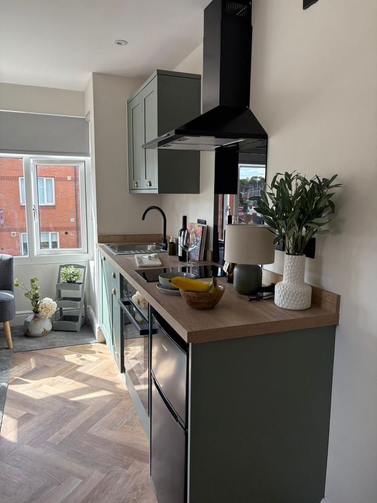 Bright, modern kitchenette with stylish sage-gr...