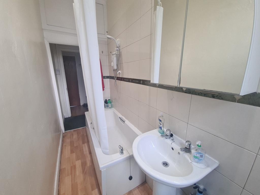 Bright and clean bathroom featuring a bathtub w...