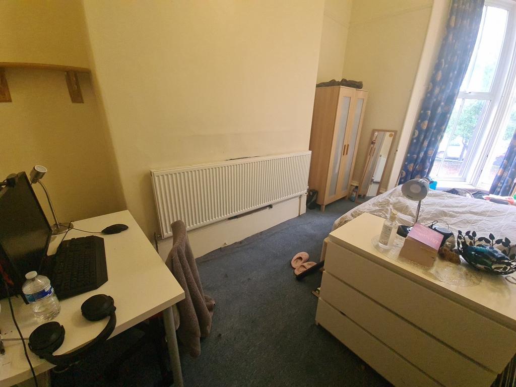 A cozy bedroom featuring a desk and chair setup...
