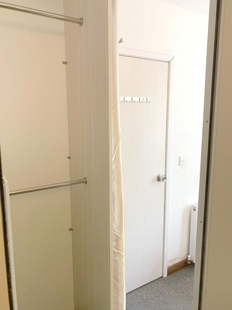 A small and clean storage area with a hanging r...