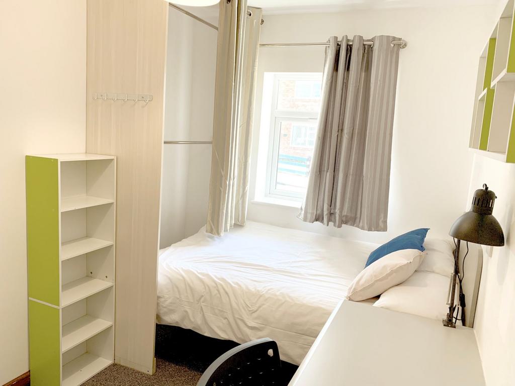 A bright and tidy double bedroom featuring a co...