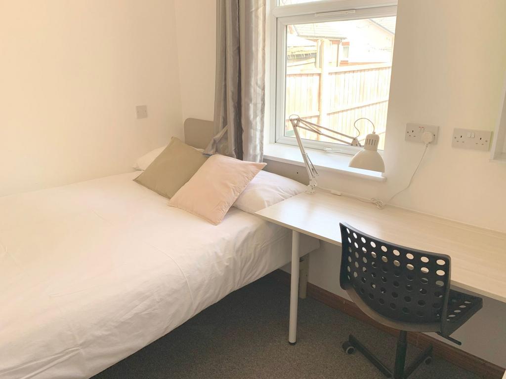 Bright and tidy single bedroom featuring a comf...