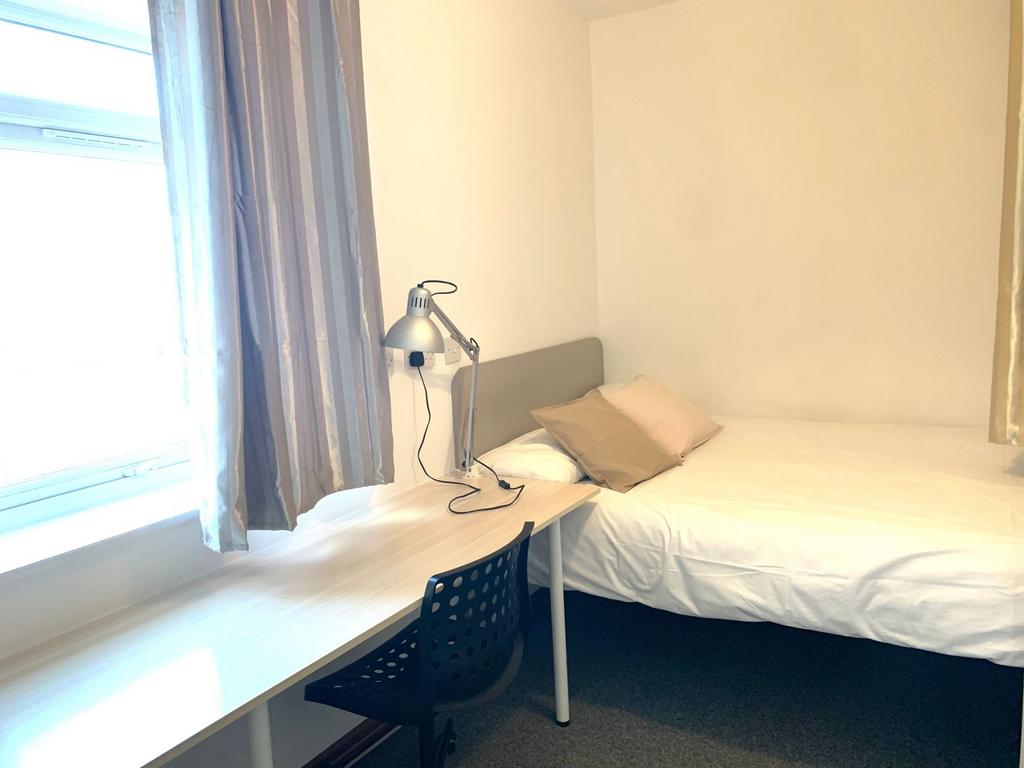 A neat and bright single bedroom featuring a co...