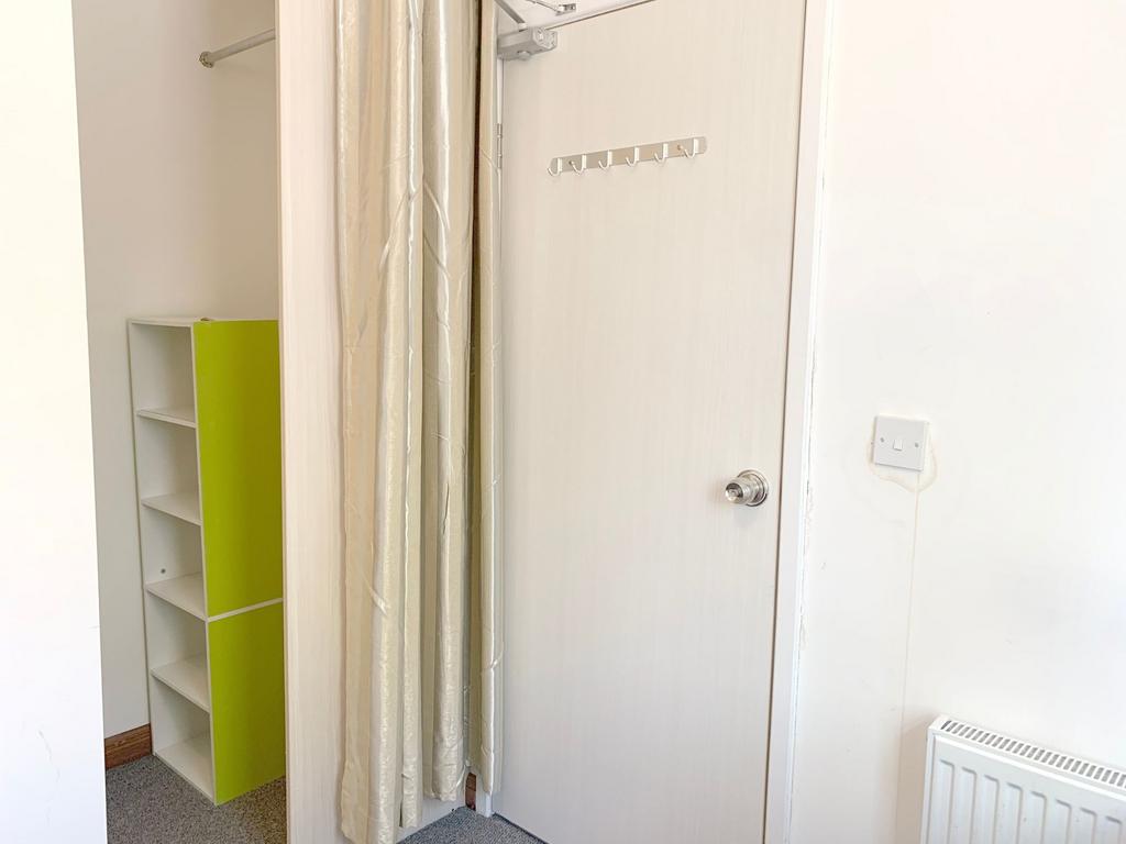 Bright and tidy hallway featuring a white door ...