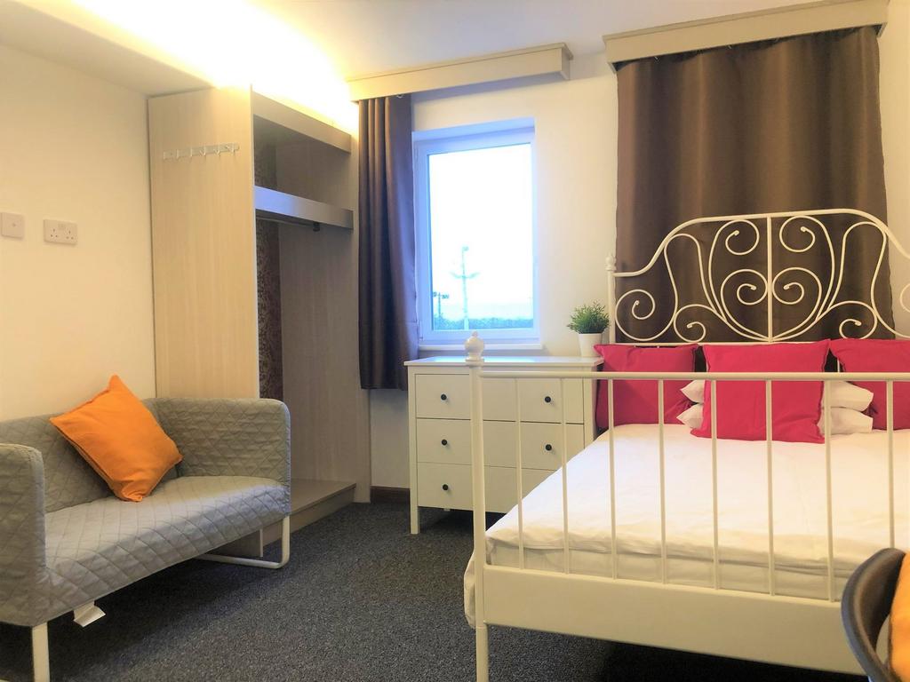 Bright and welcoming double bedroom featuring a...