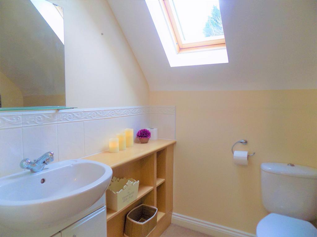 A bright and tidy bathroom with a skylight wind...
