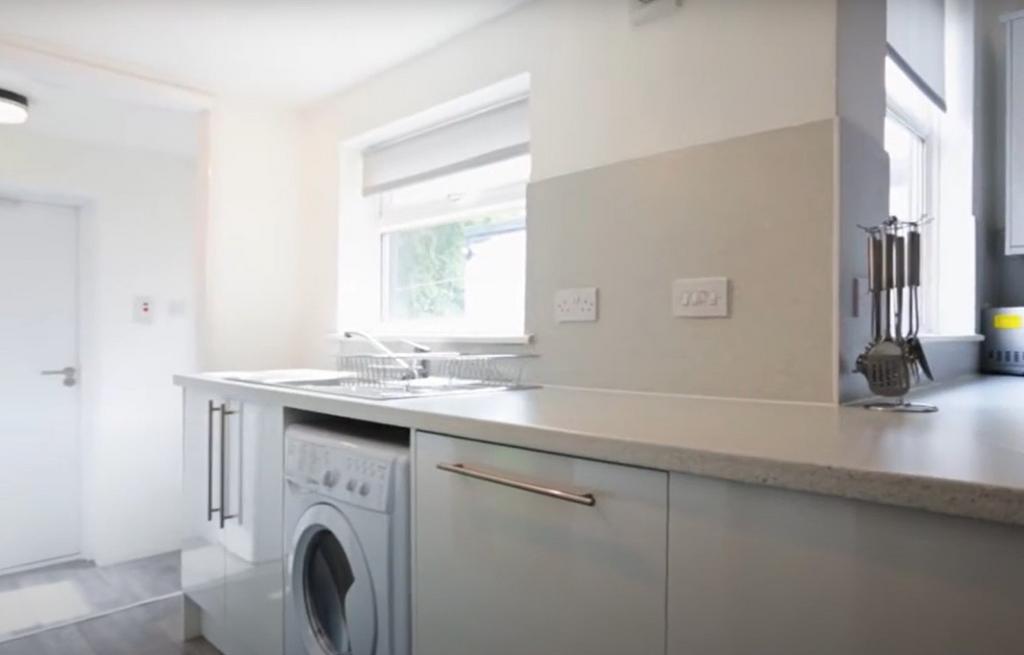 A bright and clean modern kitchen featuring a w...