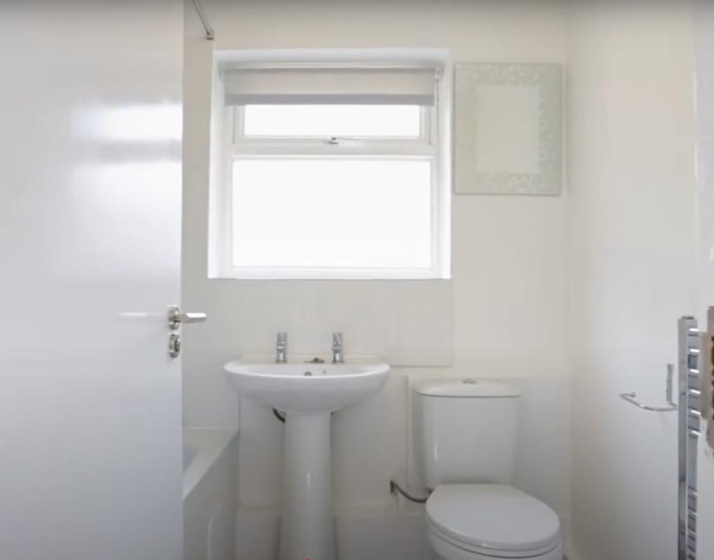 Bright, clean bathroom featuring a pedestal sin...