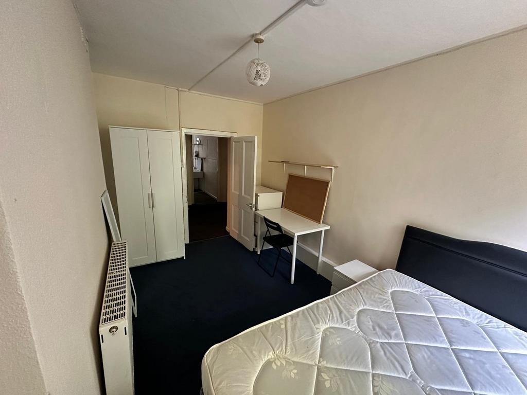 A spacious and tidy double bedroom featuring a ...