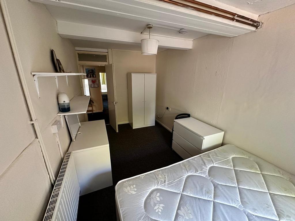 A spacious and tidy double bedroom with ample s...