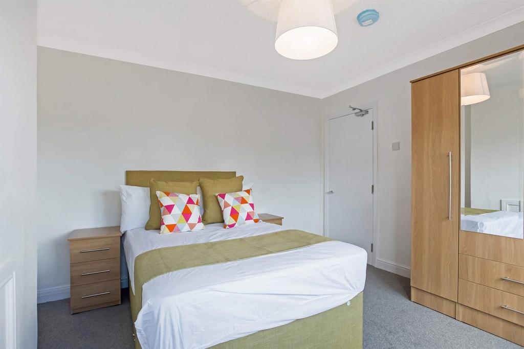 A bright and tidy double bedroom featuring a co...