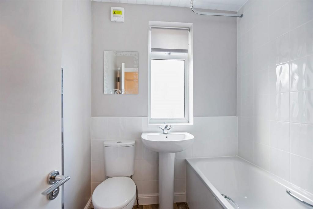 Bright and clean bathroom featuring a white bat...