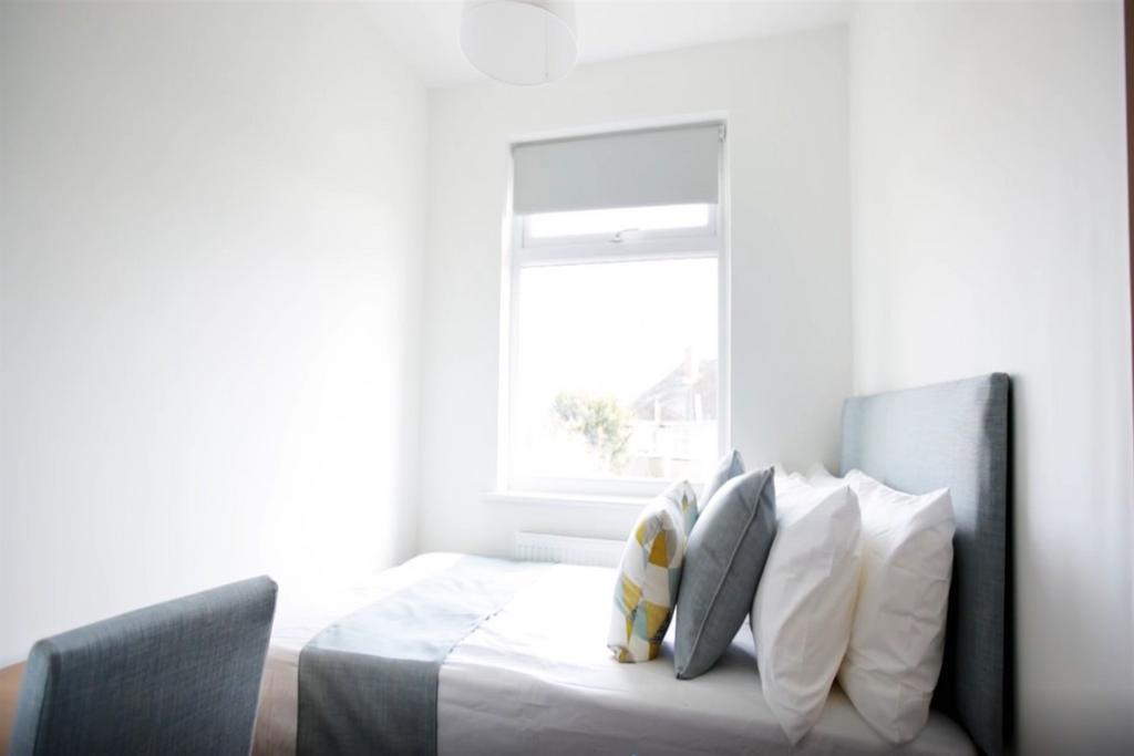 Bright and cozy single bedroom featuring a comf...