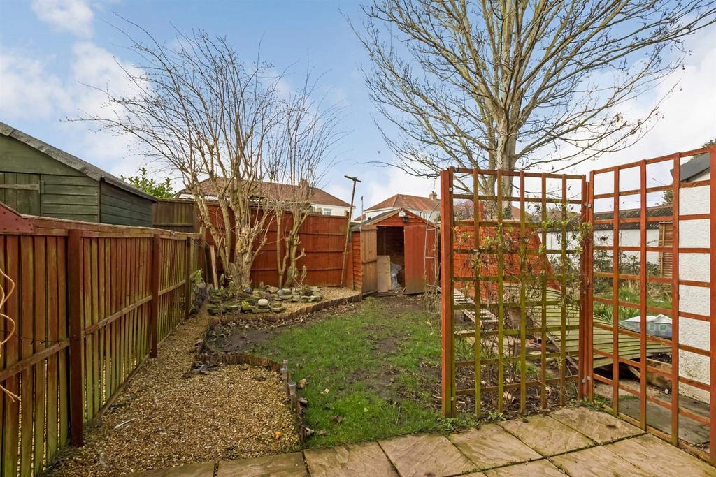 A charming garden space featuring a paved patio...