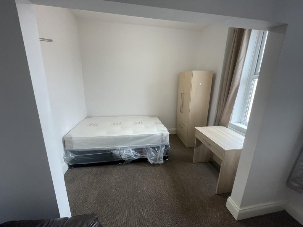 A bright and tidy single bedroom featuring a be...