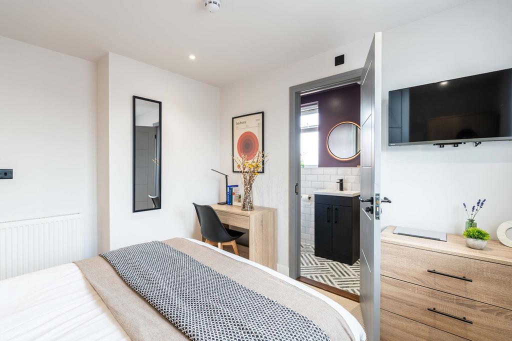 A bright and modern bedroom featuring a comfort...