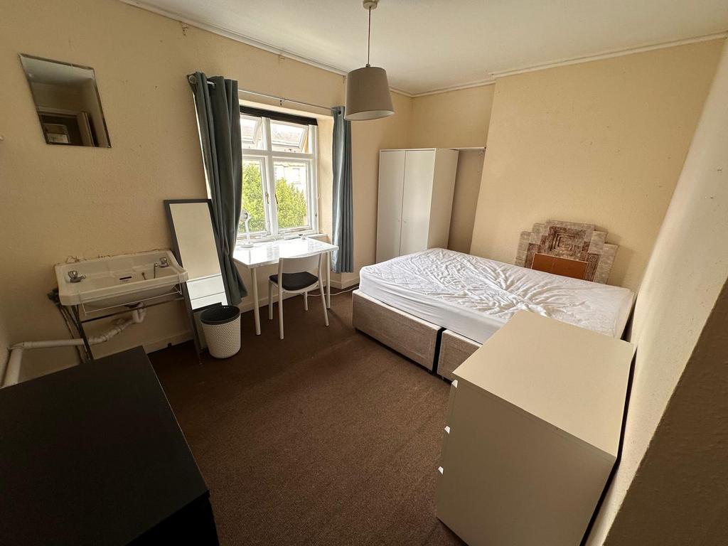 Bright double bedroom with a large window, simp...