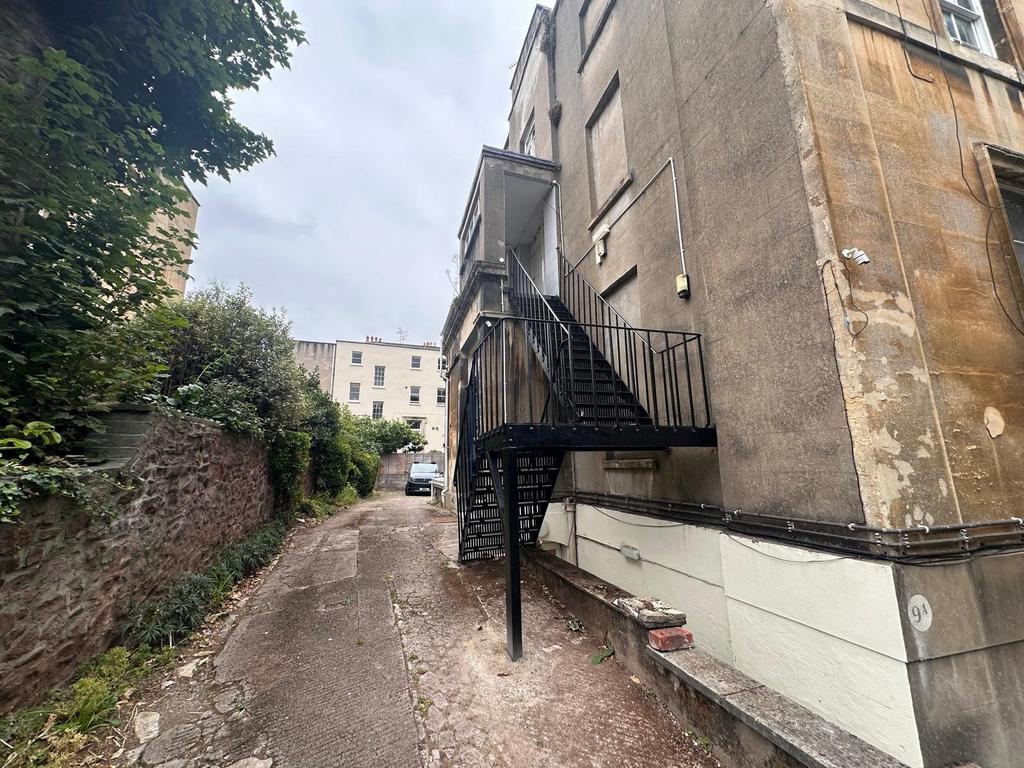 Rear access lane beside a period building with ...