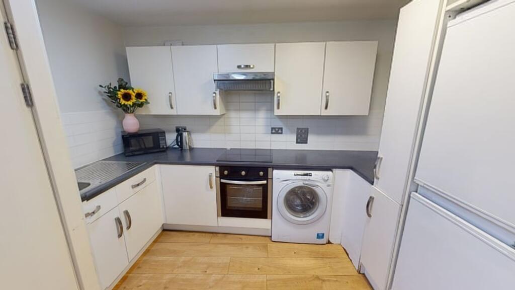 Bright and modern kitchen featuring white cabin...
