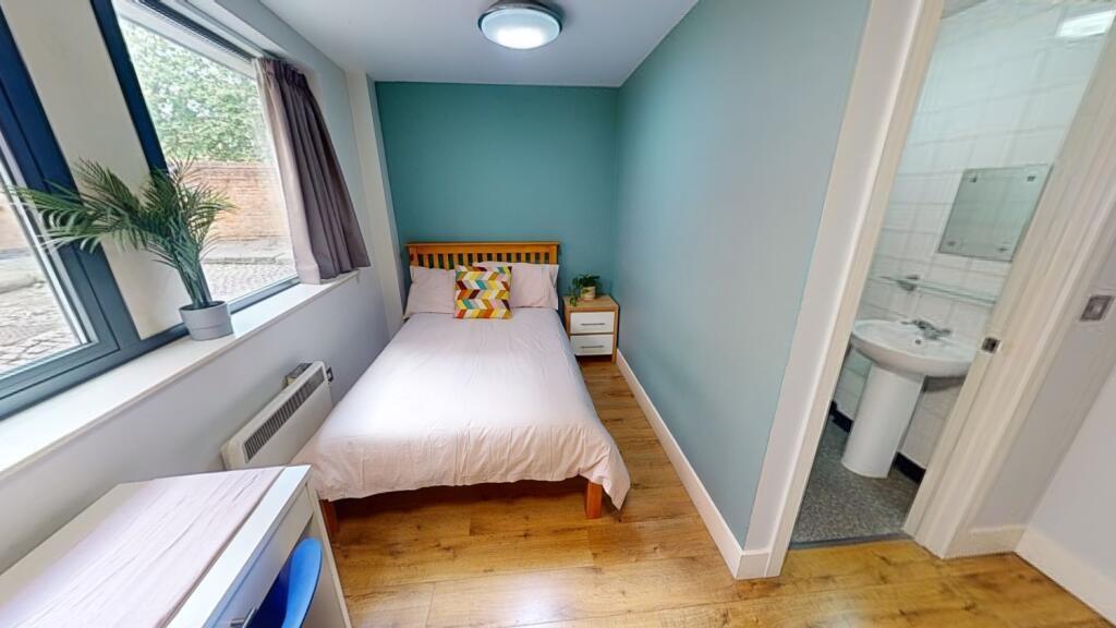 A bright and clean single toilet room featuring...