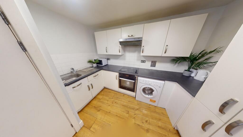 A modern and tidy kitchenette with ample storag...