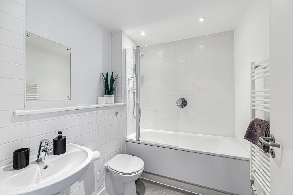 Bright and modern bathroom suite featuring a wh...