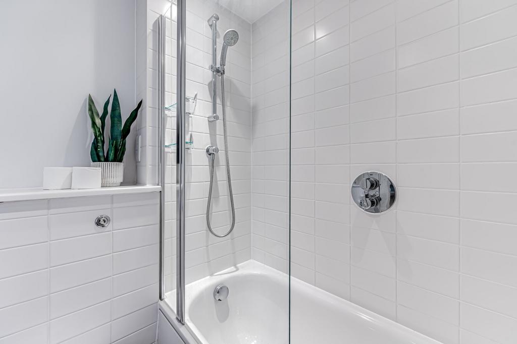 A pristine bathroom suite featuring a sleek whi...