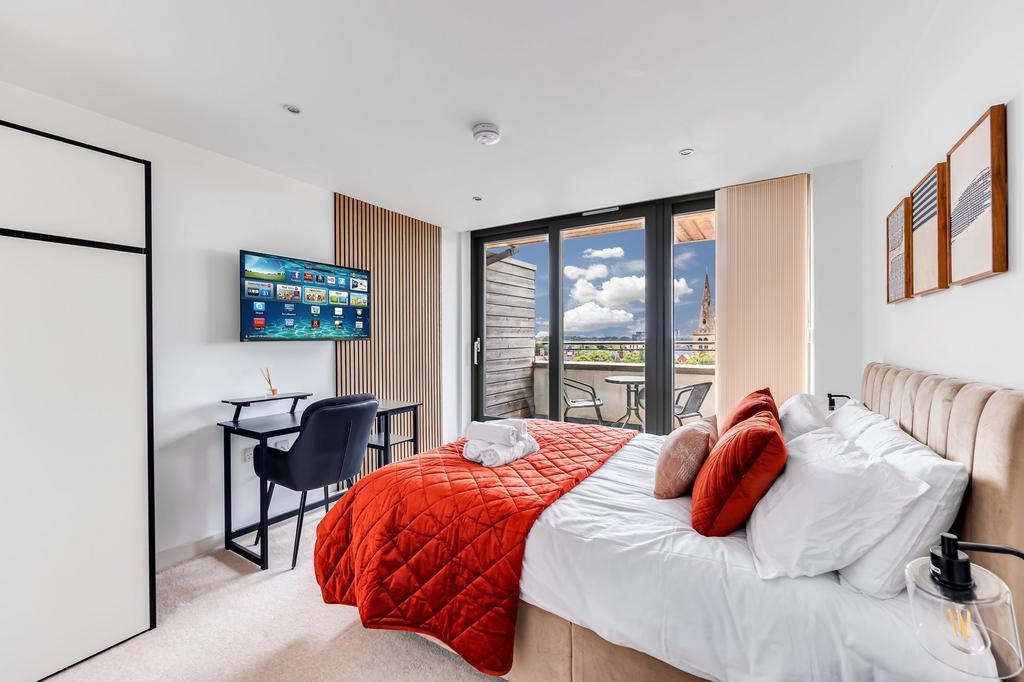 Bright and modern master bedroom featuring a co...