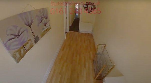 A clean and simple hallway with light wooden fl...