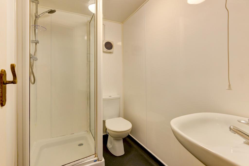 A clean and simple bathroom with a shower, toil...