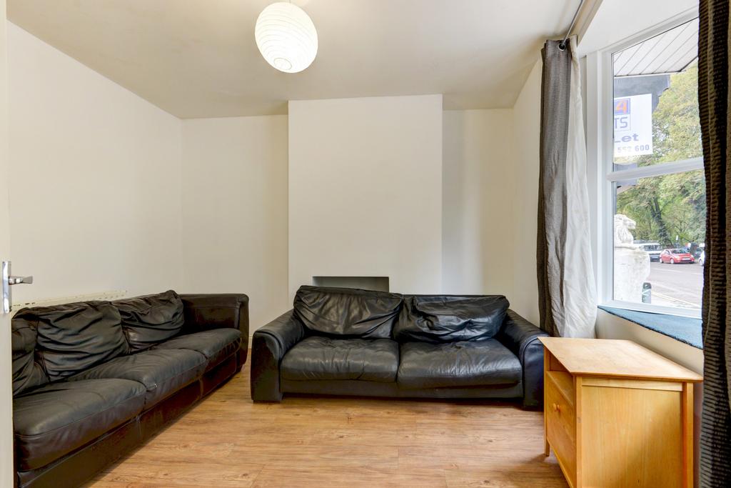 A well-lit, tidy living room featuring two larg...