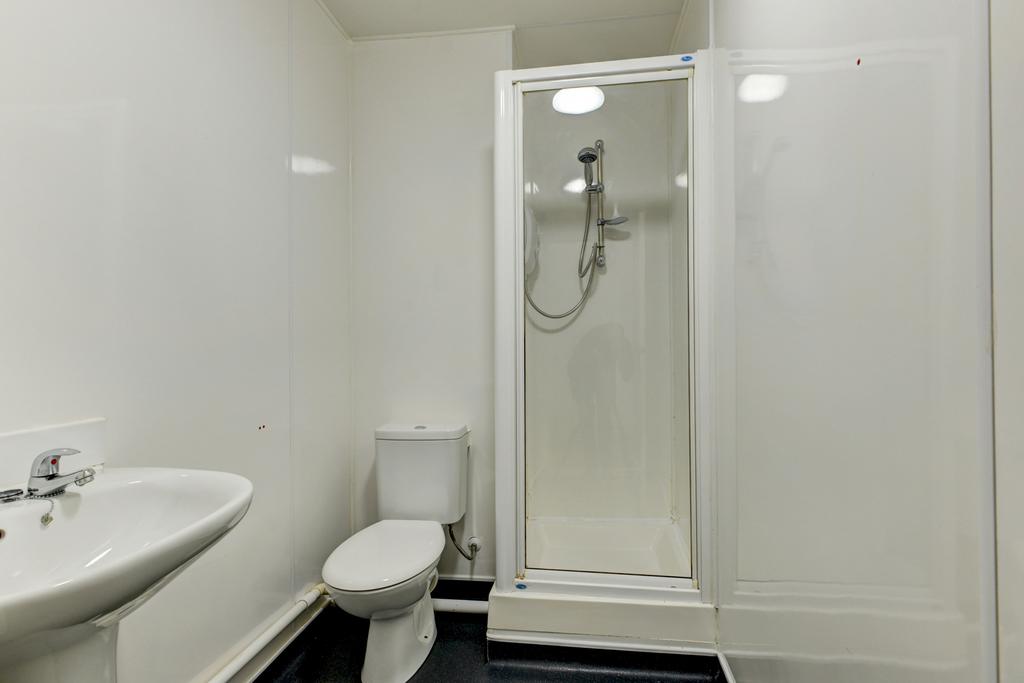 A clean and functional bathroom with a shower e...
