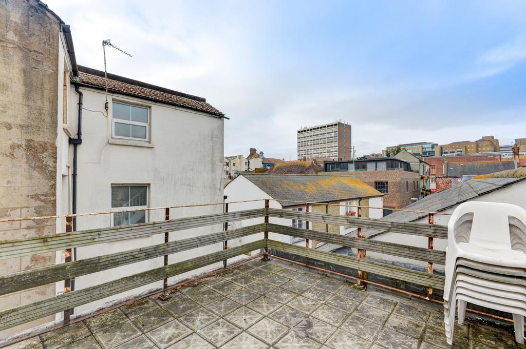 Open rooftop terrace with skyline views, paved ...