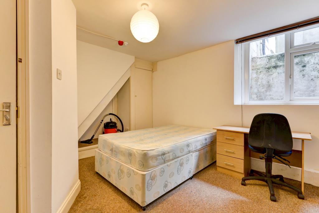 Bright, simply furnished bedroom with a double ...